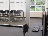 Inside a library's group study area with black chairs and a large white table.