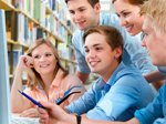 Group of young people who work together in the library in front of a computer