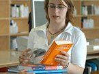 Bibliotheksmitarbeiterin verbucht Bücher im Ausleihsystem