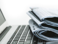 Tageszeitungen und Laptop