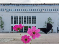 Blick vom Innenhof der Technischen Universität auf die Bibliothek mit pinker Blume im Vordergrund