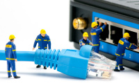 Miniaturfiguren mit Internet-Kabel vor einem Switch-Gerät