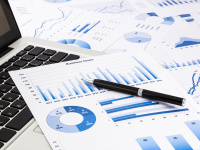 Laptop and printouts of charts and graphs
