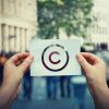 Hands holding a paper with a copyright sign like a camera