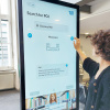 Studentin bedient den Touchscreen des digitalen Leitsystems