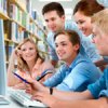 Group of young people who work together in the library in front of a computer