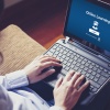 Student in front of notebook with online learning page on the desktop