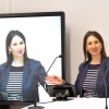 Woman at lectern, background touch display 