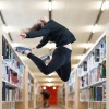 Girl jumps between bookshelfs