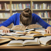 Woman lies with head on pile of books