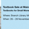 Woman with a pile of books, text Textbook Sale at Main Campus