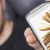 Young man presenting smartphone that shows some books