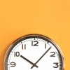 Wanduhr auf orangem Hintergrund