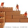 Miniature construction workers hewing bricks