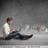 Young man sitting on the ground and letters flying from his laptop