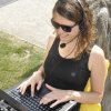 Student with laptop, headset and sunglases sitting outside in the country
