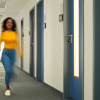 Studentin im Gang mit den Türen zu den Webinar Carrels